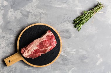 Biberiye ve baharatlar ile kesme tahtası üzerinde çiğ et sığır eti. Üst görünüm, düz yatıyordu, mockup, kopyalama alanı. Gıda konsepti