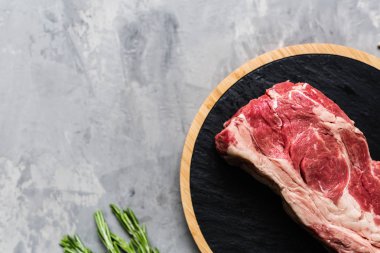 Biberiye ve baharatlar ile kesme tahtası üzerinde çiğ et sığır eti. Üst görünüm, düz yatıyordu, mockup, kopyalama alanı. Gıda konsepti