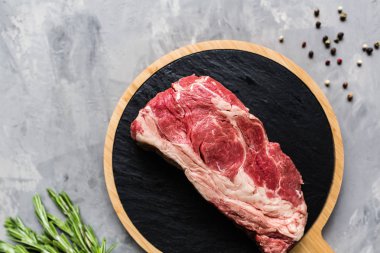 Biberiye ve baharatlar ile kesme tahtası üzerinde çiğ et sığır eti. Üst görünüm, düz yatıyordu, mockup, kopyalama alanı. Gıda konsepti