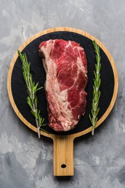Biberiye ve baharatlar ile kesme tahtası üzerinde çiğ et sığır eti. Üst görünüm, düz yatıyordu, mockup, kopyalama alanı. Gıda konsepti