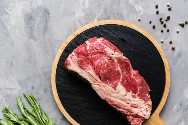 Biberiye ve baharatlar ile kesme tahtası üzerinde çiğ et sığır eti. Üst görünüm, düz yatıyordu, mockup, kopyalama alanı. Gıda konsepti