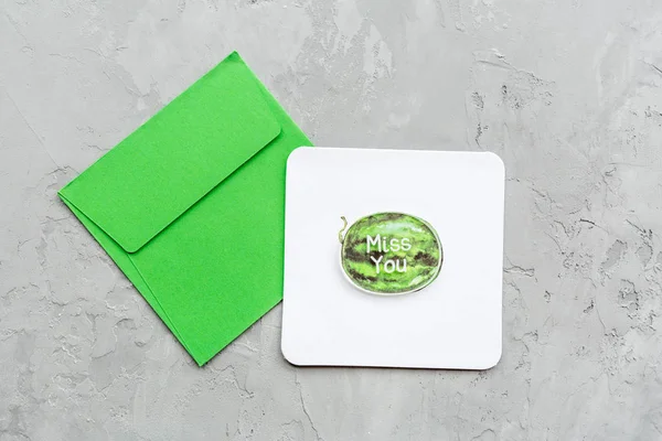 가장 작은 구성에 수박 과 녹색 봉투가 달린 종이 인사말 카드를 회색 콘 크리 이트 배경에 붙인 것이다. 흉내내고, 복사하고, 머리 위에. 납작 한 바닥. 맨 위 사진. — 스톡 사진