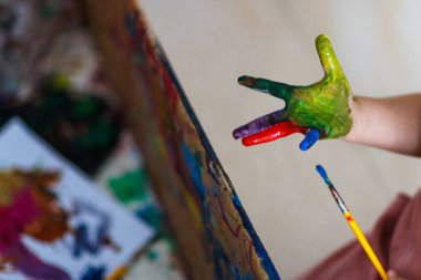 Mutlu komik kız ellerini boyayla kirletiyor.