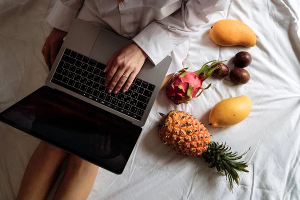 Closeup Hands of pretty young girl lying in bed and using computer at home. Beautiful slim woman working on a laptop in her bed in pajamas. Girl blogger is typing for a fresh post. Business concept — Stock Photo, Image