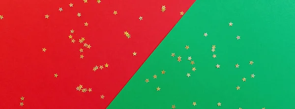 Composition de Noël. fond rouge et vert avec des confettis dorés. nouvelle année concept. Carte de voeux, célébration de Noël 2020. Pose plate, vue de dessus, espace de copie, maquette. Bannière pour la conception web — Photo