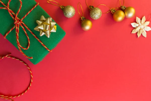 Composición navideña. regalo, juguetes dorados tumbados sobre fondo rojo. concepto de año nuevo. Tarjeta de felicitación, celebración de Navidad 2020. plano, vista superior, espacio para copiar, maqueta — Foto de Stock