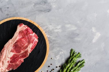 Biberiye ve baharatlar ile kesme tahtası üzerinde çiğ et sığır eti. Üst görünüm, düz yatıyordu, mockup, kopyalama alanı. Gıda konsepti