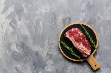 Biberiye ve baharatlar ile kesme tahtası üzerinde çiğ et sığır eti. Üst görünüm, düz yatıyordu, mockup, kopyalama alanı. Gıda konsepti