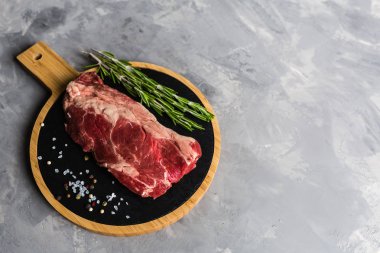 Biberiye ve baharatlar ile kesme tahtası üzerinde çiğ et sığır eti. Üst görünüm, düz yatıyordu, mockup, kopyalama alanı. Gıda konsepti