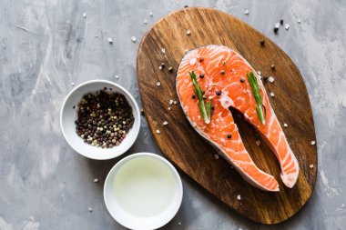 Koyu taş arka plan üzerinde baharat ile taze çiğ somon balık biftek. Balık, üst görünüm, düz yatıyordu, mockup, havai yapılmış Yaratıcı düzeni. Sağlıklı gıda, dünya gıda günü kavramı