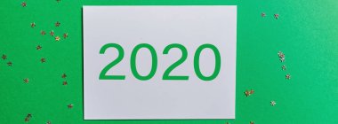 Yeşil arka planda konfetili boş bir kağıt. Yeni yıl konsepti. Kutlama kartı, xmas kutlaması 2020. Düz konum, şablon, üst görünüm, kopyalama alanı, modelleme