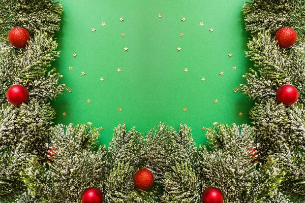 Ramas de árbol de Navidad sobre fondo verde con confeti. concepto de año nuevo. Tarjeta de felicitación, celebración de Navidad 2020. Plano, plantilla, vista superior, espacio para copiar — Foto de Stock