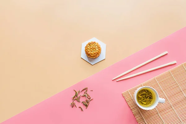 Flat lay de sobremesa do Festival Chinês, Mid Autumn Festival Bolo de lua sobre fundo colorido com chá verde e pauzinhos. Visão superior, espaço de cópia, mockup, sobrecarga, modelo — Fotografia de Stock