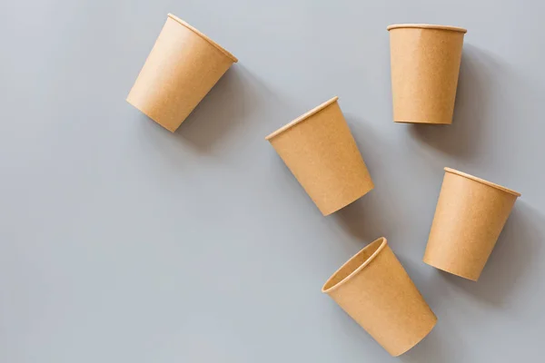 Eko doğal kağıt kahve fincanları gri arka planda yatıyordu. Sürdürülebilir yaşam tarzı kavramı. sıfır atık, plastiksiz eşyalar. Plastik kirliliğini durdurun. Üst görünüm, genel görünüm, model, şablon — Stok fotoğraf