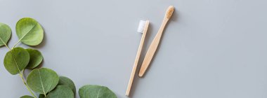 Eko doğal bambu diş fırçaları gri arka planda yatıyordu. Sürdürülebilir yaşam tarzı kavramı. sıfır atık, plastiksiz eşyalar. Plastik kirliliğini durdurun. Üst görünüm, genel görünüm, şablon, model.