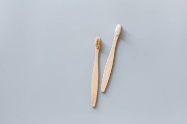 Eko doğal bambu diş fırçaları gri arka planda yatıyordu. Sürdürülebilir yaşam tarzı kavramı. sıfır atık, plastiksiz eşyalar. Plastik kirliliğini durdurun. Üst görünüm, genel görünüm, şablon, model.