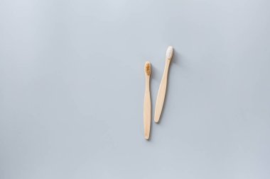 Eko doğal bambu diş fırçaları gri arka planda yatıyordu. Sürdürülebilir yaşam tarzı kavramı. sıfır atık, plastiksiz eşyalar. Plastik kirliliğini durdurun. Üst görünüm, genel görünüm, şablon, model.
