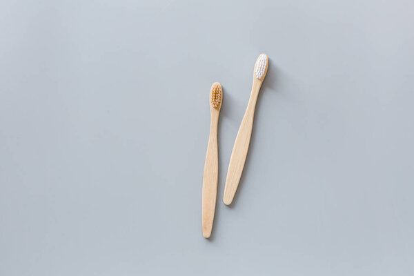 eco natural bamboo toothbrushes flat lay on gray background. sustainable lifestyle concept. zero waste, plastic free items. stop plastic pollution. Top view, overhead, template, Mockup.