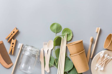 Çevresel doğal kağıt bardaklar, pipetler, diş fırçası düz gri arka planda yatıyordu. Sürdürülebilir yaşam tarzı kavramı. sıfır atık, plastiksiz eşyalar. Plastik kirliliğini durdurun. Üst görünüm, genel görünüm, şablon, model.