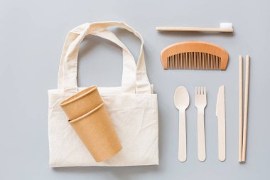 Çevresel doğal kağıt bardaklar, pipetler, diş fırçası düz gri arka planda yatıyordu. Sürdürülebilir yaşam tarzı kavramı. sıfır atık, plastiksiz eşyalar. Plastik kirliliğini durdurun. Üst görünüm, genel görünüm, şablon, model.