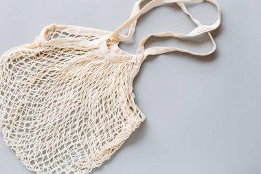 Beyaz çevre dostu sicim torbası gri arka planda izole edilmiş, tüketimden sorumlu. Ekolojik yaşam tarzı, yeşil ve plastiksiz yaşam tarzı. Düz konum, üst görünüm, model, genel görünüm, şablon