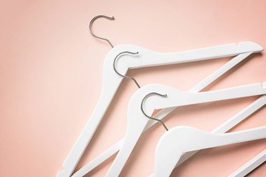 Pastel turuncu arka planda beyaz ahşap askılar. Moda kadınsı blog satış mağazası tanıtım tasarımı alışveriş konsepti. Düz yatış, üst görünüm, model, genel giderler