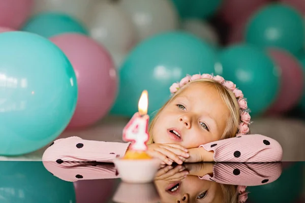 Beltéri lövés szép örömteli kislány szőke haja fúj ki a gyertyát, ünnepelni 4 éves születésnapját, kopás divatos ruha, már izgatott kifejezéseket. Boldog gyermekkori koncepció — Stock Fotó