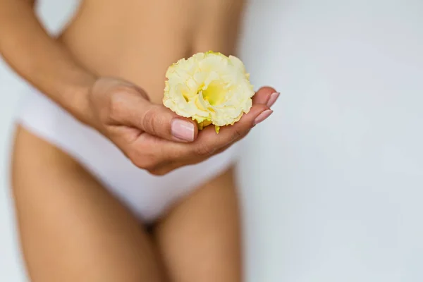 Woman holding flower on front of her private parts. Feminine hygiene alternative product instead of tampon during period. Menstruation, critical days, women periods. Zero waste, eco, ecology. — Stock Photo, Image