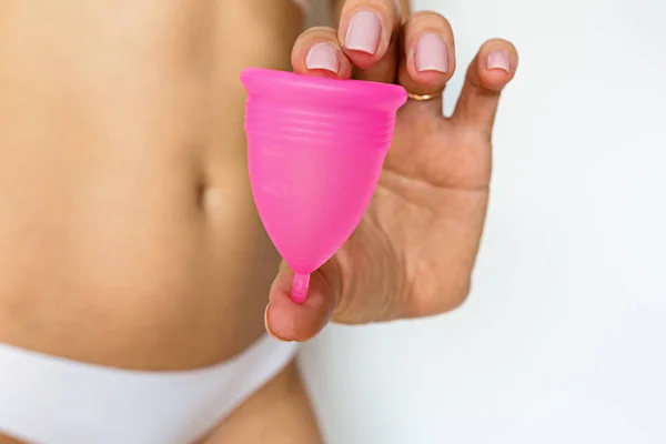 Žena držící menstruační pohár před svými intimními partiemi. Ženská hygiena alternativní produkt místo tampónu během období. Menstruace, kritické dny, menstruace pro ženy. Nulový odpad, ekologie, ekologie. — Stock fotografie