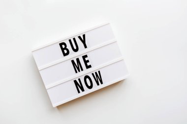 Yaratıcı promosyon kompozisyonu, beyaz arka plandaki ışık kutusunda bana şimdi metin satın al. Düz konum, üst görünüm, genel görünüm, model, kopyalama alanı, şablon