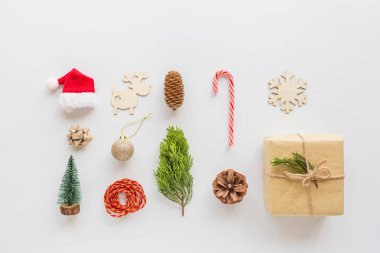 Noel kompozisyonu. Paketlenmiş hediye, tahta oyuncaklar, beyaz çubuk lolipop. Yeni yıl konsepti. Tebrik kartı, kış tatili, kostüm kutlaması 2020. Düz konum, üst görünüm, kopyalama alanı, model, şablon