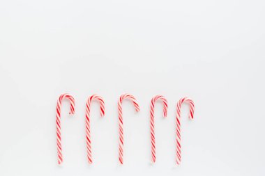 Noel kompozisyonu. Beyaz arka planda lolipop çubukları. Yeni yıl konsepti. Tebrik kartı, kış tatili, kostüm kutlaması 2020. Düz konum, üst görünüm, kopyalama alanı, model, şablon