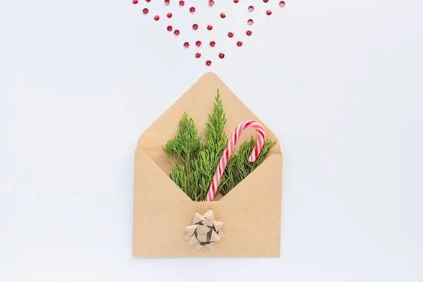 Vánoční kompozice. Papírová obálka s jedlovými větvemi a kuželem na bílém. novoroční koncept. Pozdrav, zimní prázdniny, vánoční oslavy2020. Byt ležel, pohled shora, maketa, šablona — Stock fotografie
