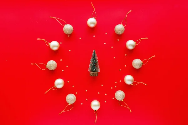Різдвяна ялинка золоті іграшки та дерево, що лежить на червоному тлі. концепція нового року. Вітальна листівка, зимові свята, святкування Різдва 2020 року. Плоский простір, вид зверху, простір для копіювання, макет, шаблон — стокове фото