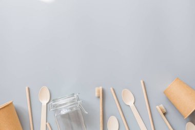 Çevresel doğal kağıt bardaklar, pipetler, diş fırçası düz gri arka planda yatıyordu. Sürdürülebilir yaşam tarzı kavramı. sıfır atık, plastiksiz eşyalar. Plastik kirliliğini durdurun. Üst görünüm, genel görünüm, şablon, model.