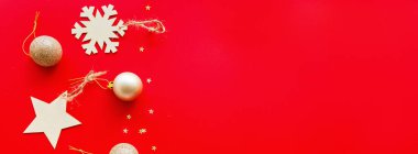 Kırmızı arka planda duran Noel ağacı altın oyuncakları. Yeni yıl konsepti. Web tasarımı için yatay uzun pankart. Kutlama kartı, xmas kutlaması 2020. Düz yatış, üst görünüm, kopyalama alanı, maket, şablon