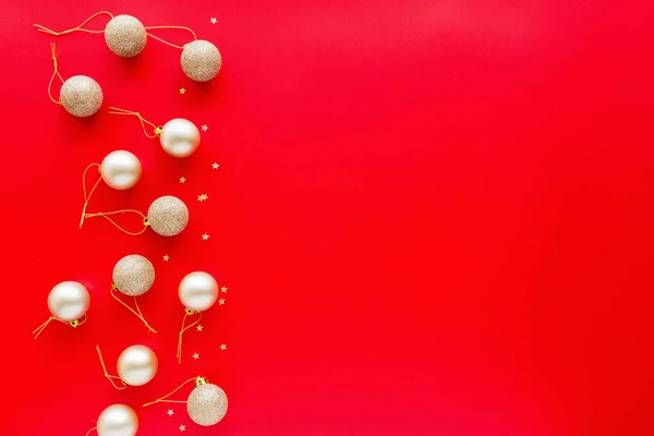 Χριστουγεννιάτικα δέντρα χρυσά παιχνίδια που βρίσκονται σε κόκκινο φόντο. έννοια του νέου έτους. Ευχετήρια κάρτα, χειμερινές διακοπές, Χριστούγεννα 2020 γιορτή. Επίπεδη lay, top view, αντιγραφή χώρου, μακιγιάρισμα, πρότυπο — Φωτογραφία Αρχείου