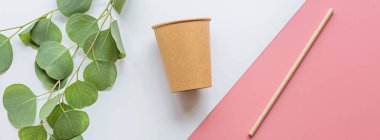 Çevresel kağıt kahve fincanı ve saman düz beyaz ve pembe arka planda yatıyordu. Web tasarımı için yatay uzun pankart. Sürdürülebilir yaşam tarzı kavramı. sıfır atık, plastiksiz. Plastik kirliliğini durdur