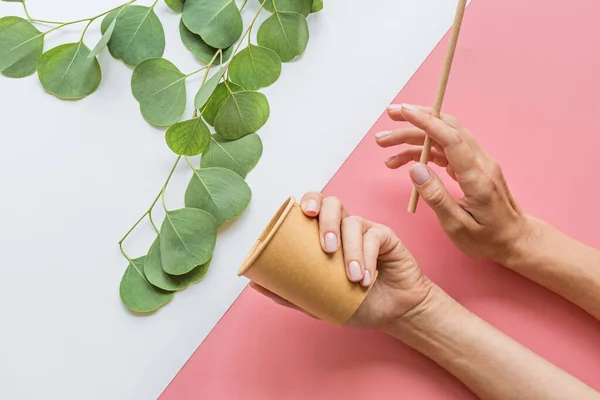 Eco taza de café de papel natural, mano y paja plana yacen sobre fondo blanco y rosa. concepto de estilo de vida sostenible. cero residuos, artículos libres de plástico. detener la contaminación plástica. Vista superior, techo, maqueta — Foto de Stock