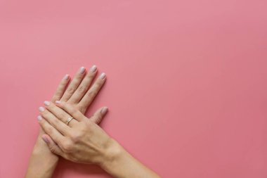 Modaya uygun pembe kadın manikürü. Güzel genç kadın pembe pastel arka planda mesaj için yer var. Asgari yaratıcı konsept. Düz konum, üst görünüm, maket, boşluk kopyala, şablon