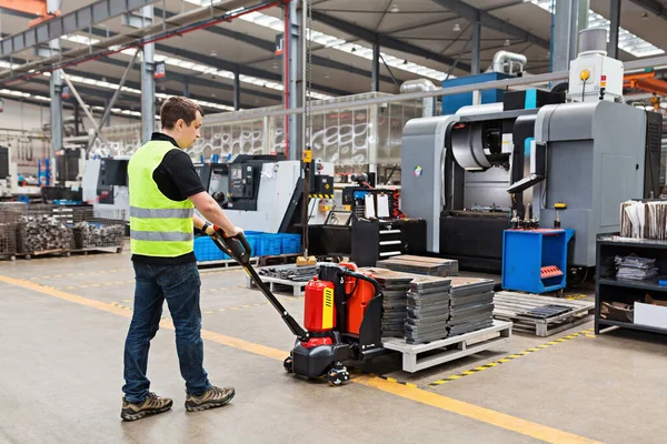 Depo işçisi palet taşıyan el arabası ya da yük paleti boşaltılan el yapımı forklift kullanıyor. Dağıtım, Lojistik İthalat İhracat, Ticaret, Sevkiyat, Teslimat konsepti