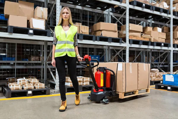 Magazijnmedewerker die handpallettrucks of handmatige vorkheftrucks meesleept met de transportpallet die in een vrachtwagen wordt gelost. Distributie, Logistiek Import Export, Handel, Verzending, Levering concept — Stockfoto