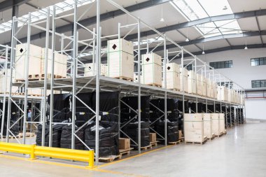 Endüstriyel ve lojistik şirketlerinin olduğu büyük bir hangar. Çeşitli kutularla dolu uzun raflar. Teslimat için sanayi alanı ve donanım kutusu, iş lojistik dağıtım depolama kargo kavramı.