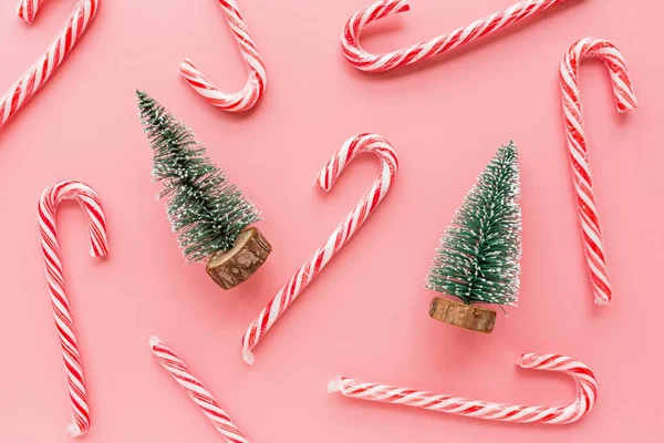 Horní pohled na vánoční strom s mnoha candy canes na pastelové růžové pozadí. Vánoční přání k oslavě svátků. Mockup, šablona. Vánoční koncept s dárkem sladkostí, šťastný nový rok 2020 — Stock fotografie