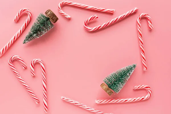 Horní pohled na vánoční strom s mnoha candy canes na pastelové růžové pozadí. Dovolená slavnostní přání na uvítanou s kopií prostoru pro text. Mockup, šablona. Vánoční koncept, šťastný nový rok 2020 — Stock fotografie