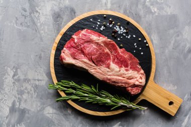 Biberiye ve baharatlar ile kesme tahtası üzerinde çiğ et sığır eti. Üst görünüm, düz yatıyordu, mockup, kopyalama alanı. Gıda konsepti