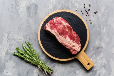 Biberiye ve baharatlar ile kesme tahtası üzerinde çiğ et sığır eti. Üst görünüm, düz yatıyordu, mockup, kopyalama alanı. Gıda konsepti