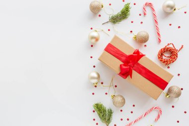 Noel kompozisyonu. Paketlenmiş hediye, beyaz arka planda duran tahta oyuncaklar. Yeni yıl konsepti. Tebrik kartı, kış tatili, kostüm kutlaması 2020. Düz konum, üst görünüm, kopyalama alanı, model, şablon