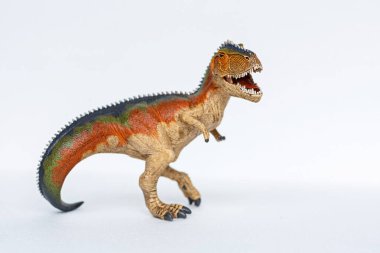 Beyaz arka planda duran dinozor oyuncağı. Tyrannosaur Rex oyuncağı