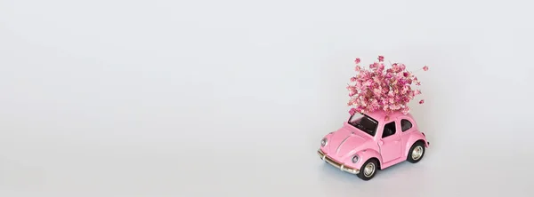 분홍색 역 장난감 자동차가 흰색 꽃들의 부케를 나르고 있습니다. 발렌타인데이 2 월 14 일 카드. 국제 여성의 날 3 월 8 일, 어머니 날, 생일 선물. 복사 공간, 흉내, 주형, 최소화 — 스톡 사진